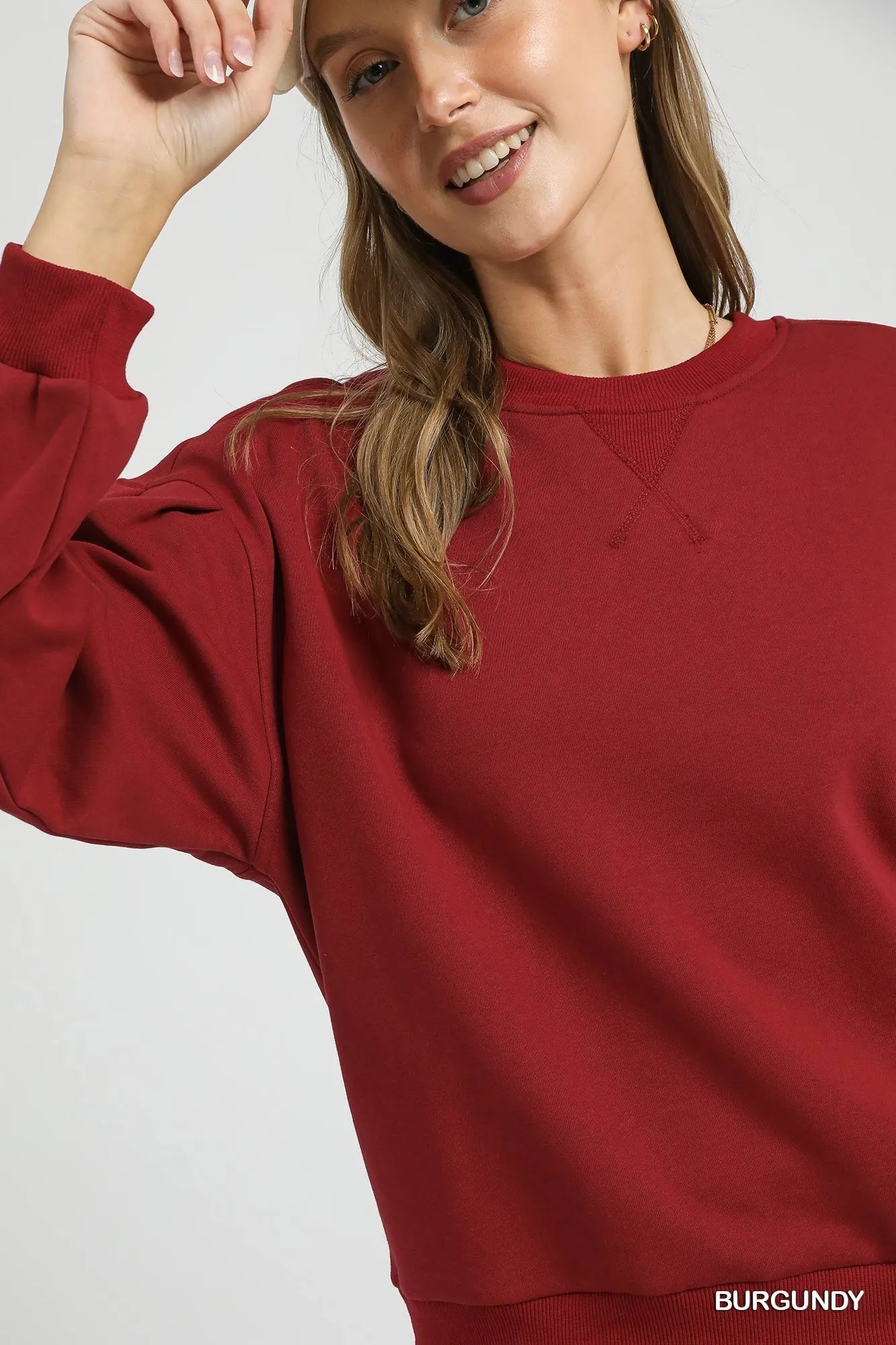Trendy Umgee round neck sweatshirt with pleated detail, soft fabric, and casual fit perfect for everyday wear.