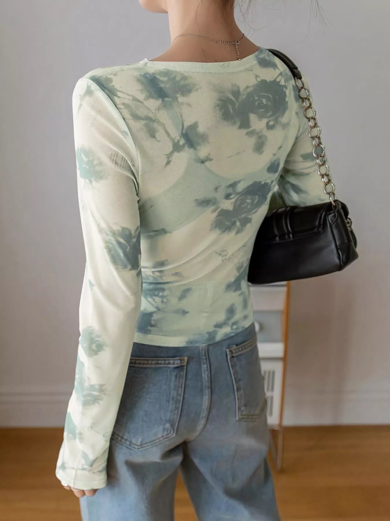 Floral print sheer mesh long sleeve T-shirt by Trendsi featuring a lightweight, see-through design with colorful floral patterns.