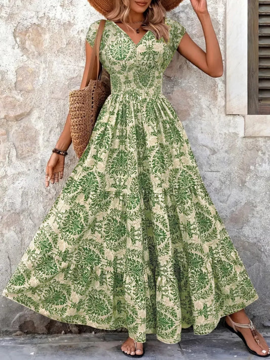 Plus size printed V-neck tiered maxi dress by Trendsi featuring a full-length design and flowing fabric.