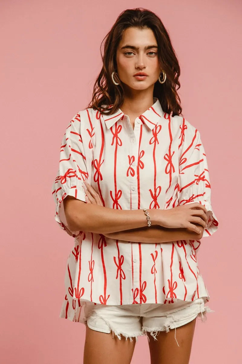 Woven printed button-down shirt with BiBi Bow Ribbon details from Trendsi, featuring a colorful, patterned fabric and classic collar.