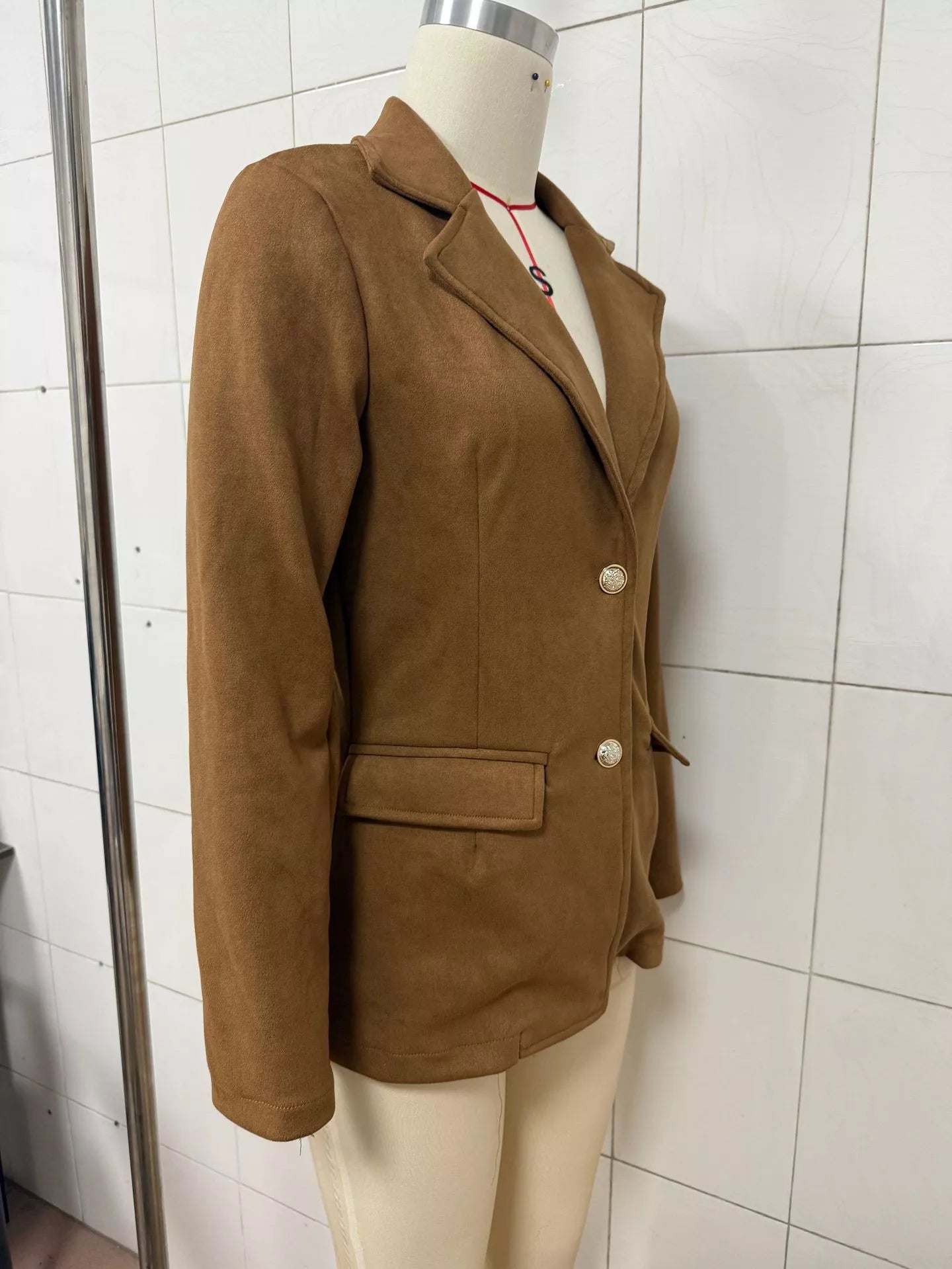 Black single-breasted blazer with lapel collar from Trendsi, shown on a hanger, featuring a tailored fit and sleek design.