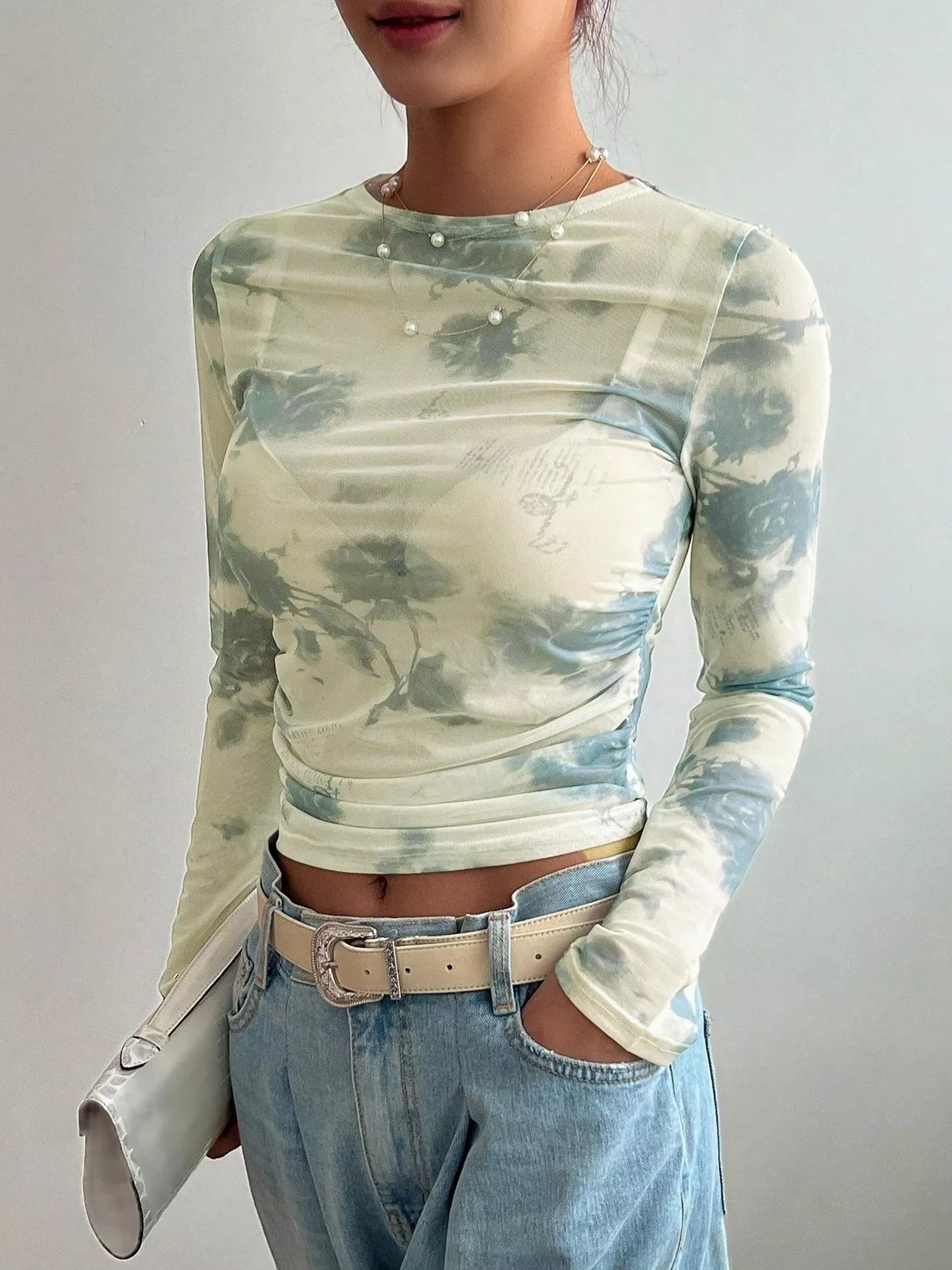 Floral print sheer mesh long sleeve T-shirt from Trendsi featuring a lightweight, see-through fabric with vibrant floral patterns.