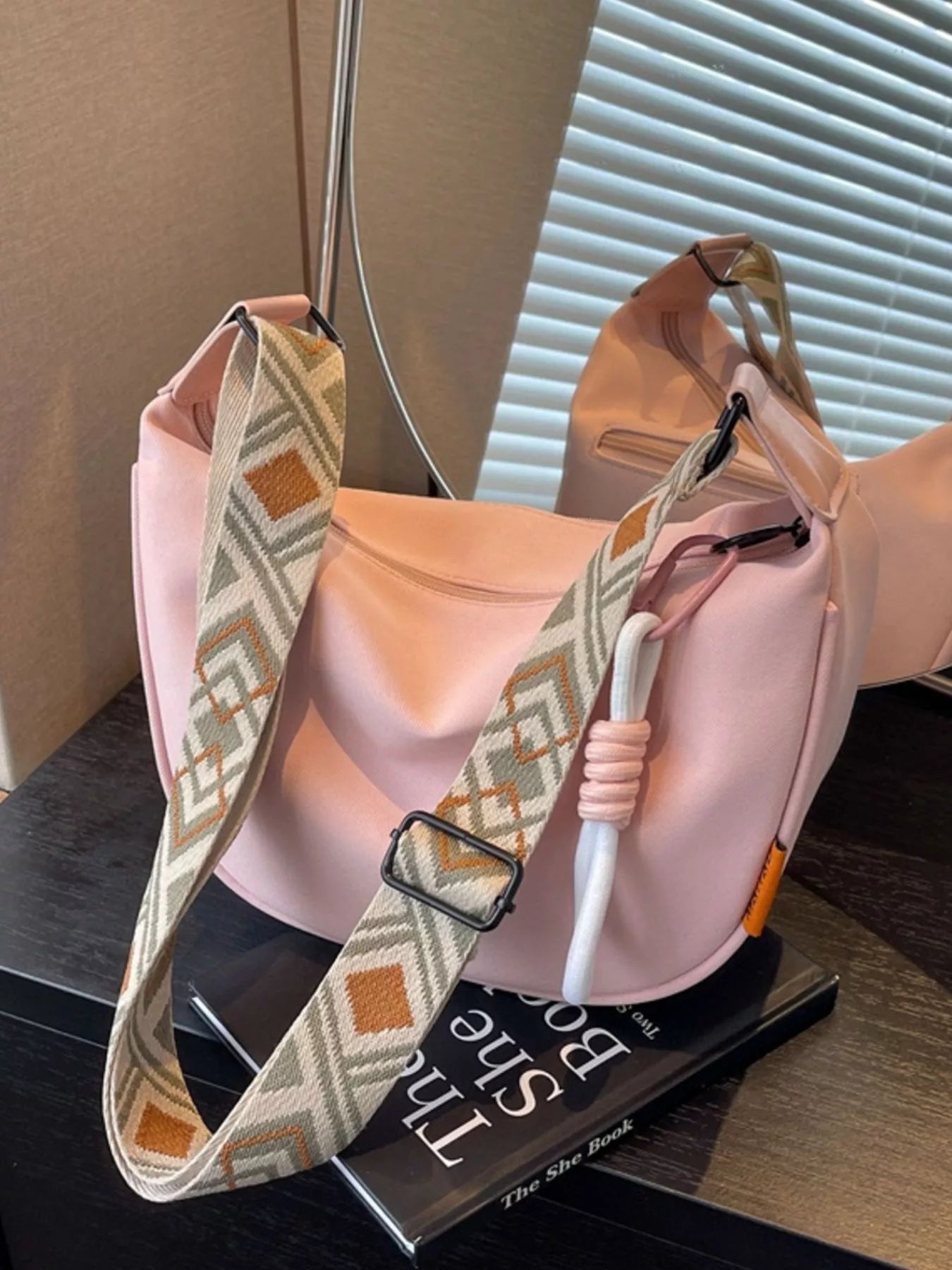 Trendsi geometric strap crossbody bag with modern design, featuring a structured shape and adjustable strap on a neutral background.