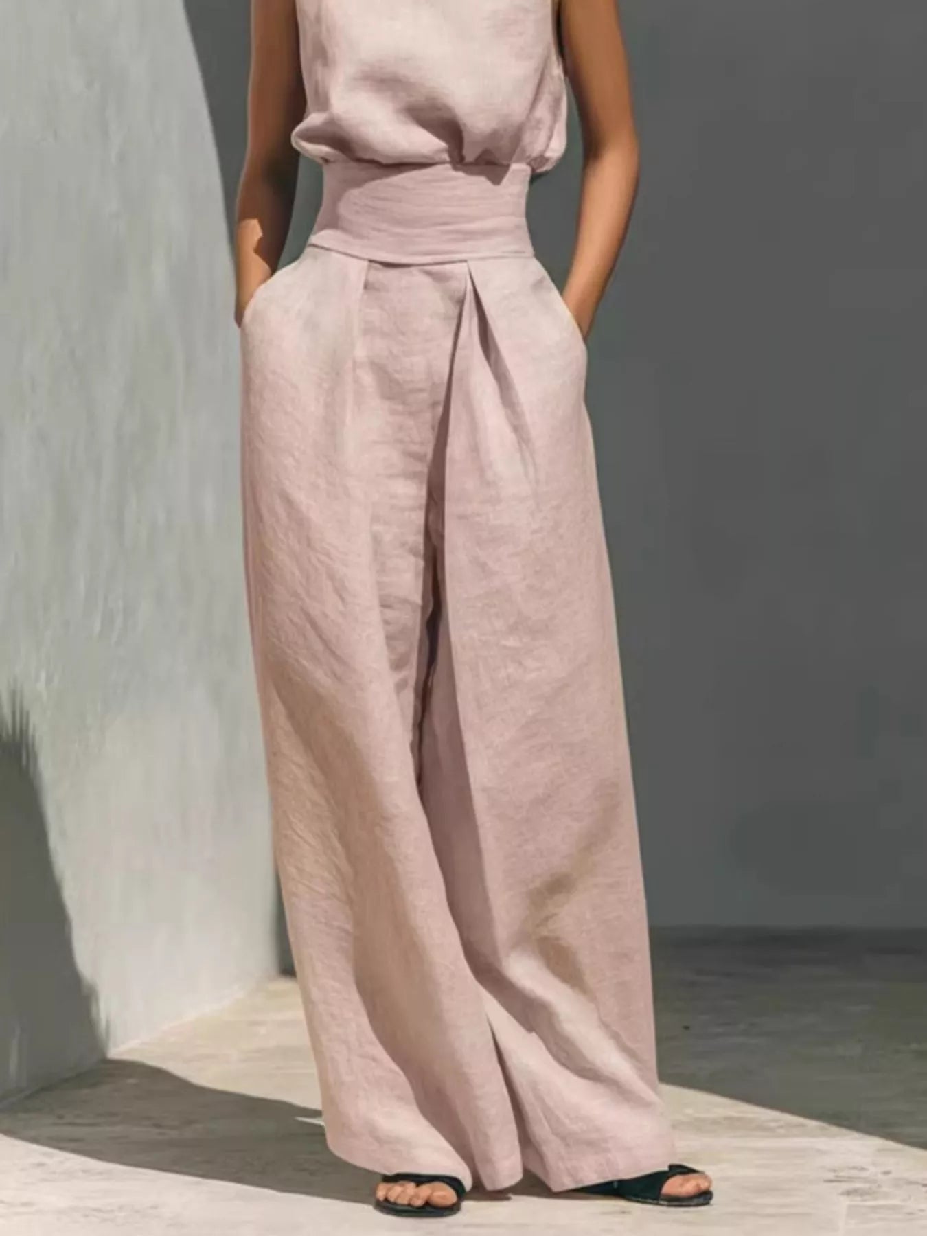 Plus size sleeveless wide-leg jumpsuit with smocked waist by Trendsi, featuring a full-length design and flowy silhouette.