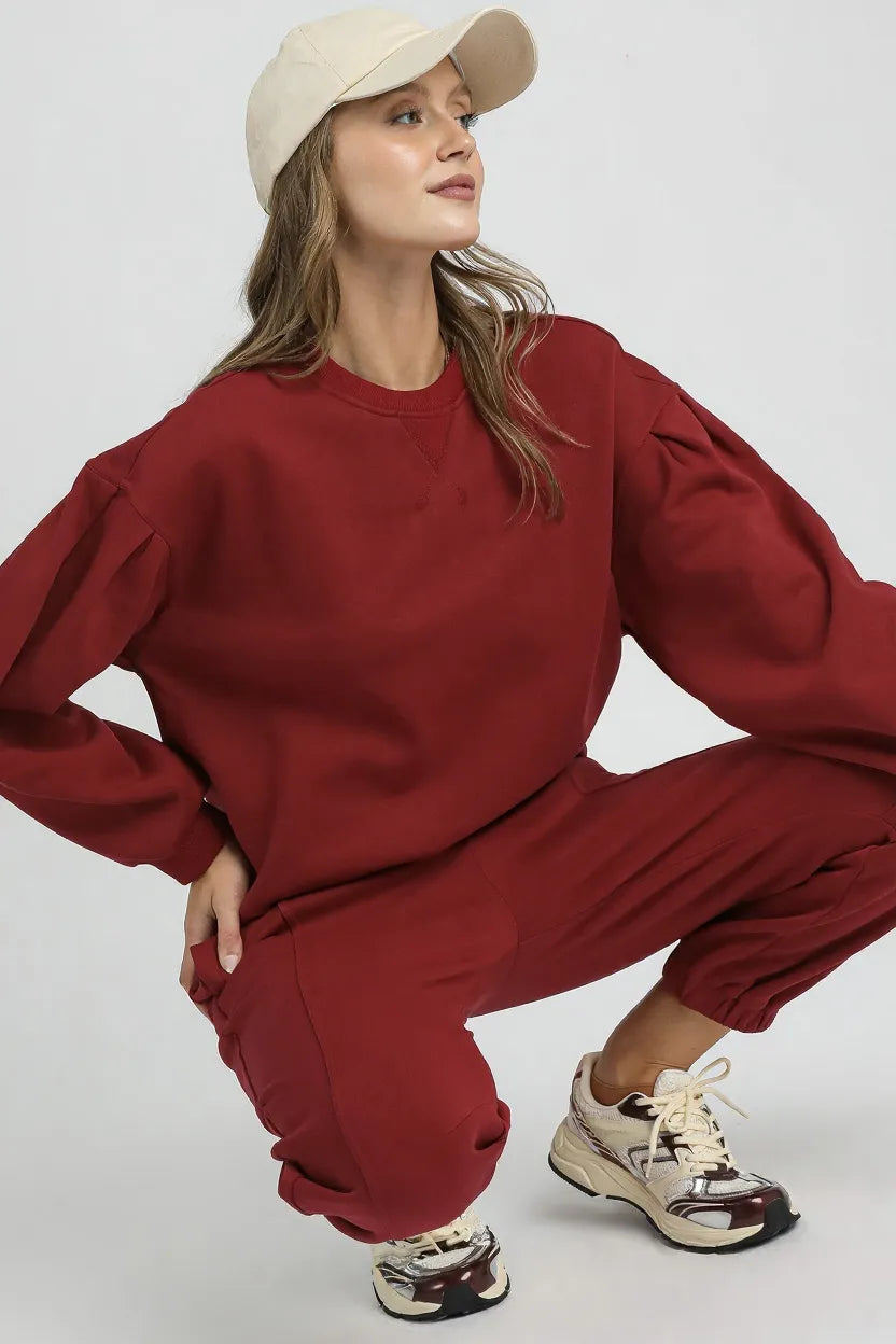 Trendsi Umgee round neck sweatshirt with pleated detail, soft fabric, and casual fit, displayed on a hanger.