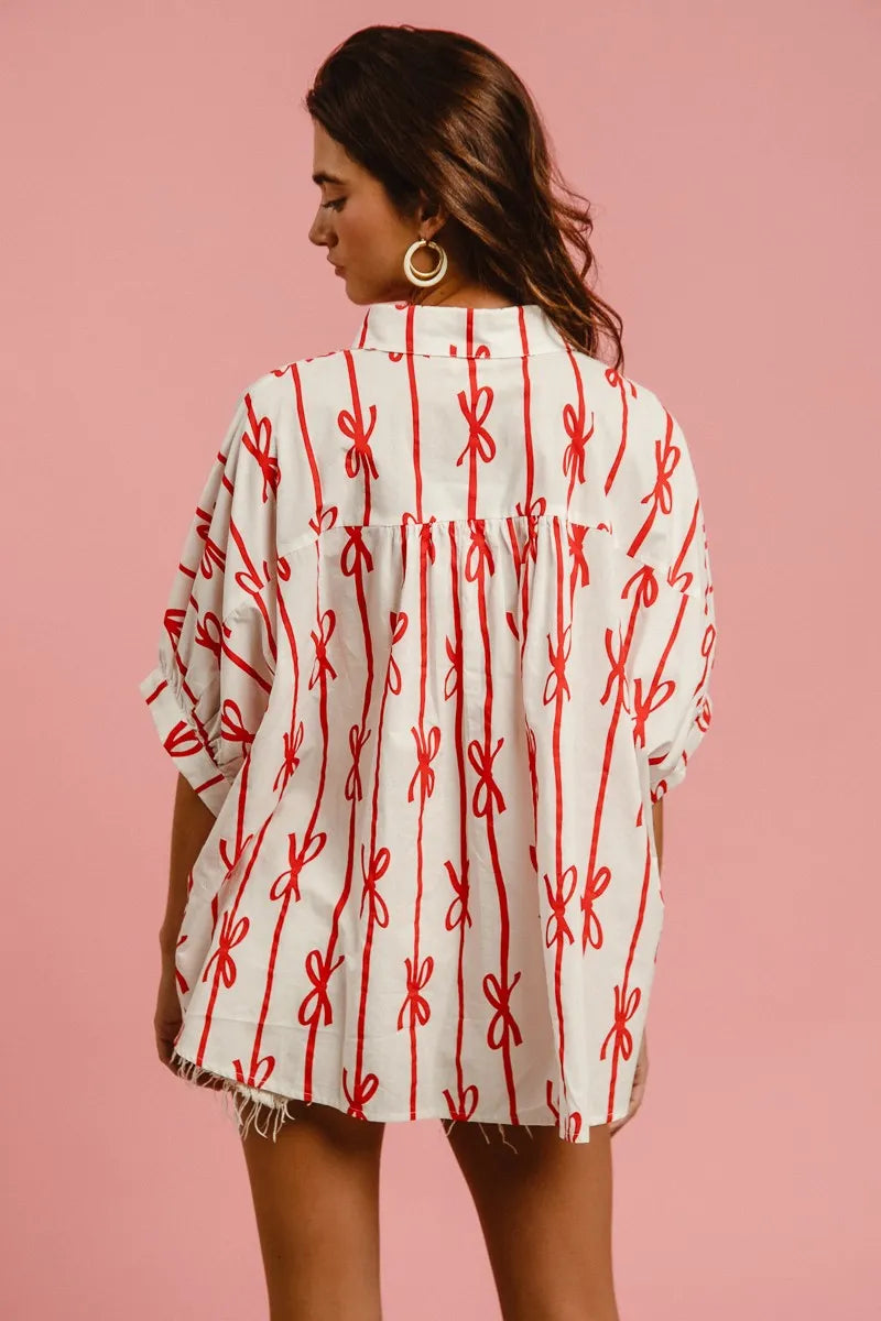Woven printed button-down shirt with BiBi Bow Ribbon detailing from Trendsi, featuring a stylish, casual design in soft fabric.