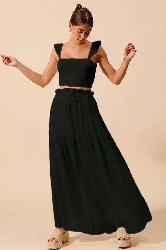 Black SO ME smocked top and flowy maxi skirt set by Trendsi, featuring a stylish, comfortable matching ensemble.