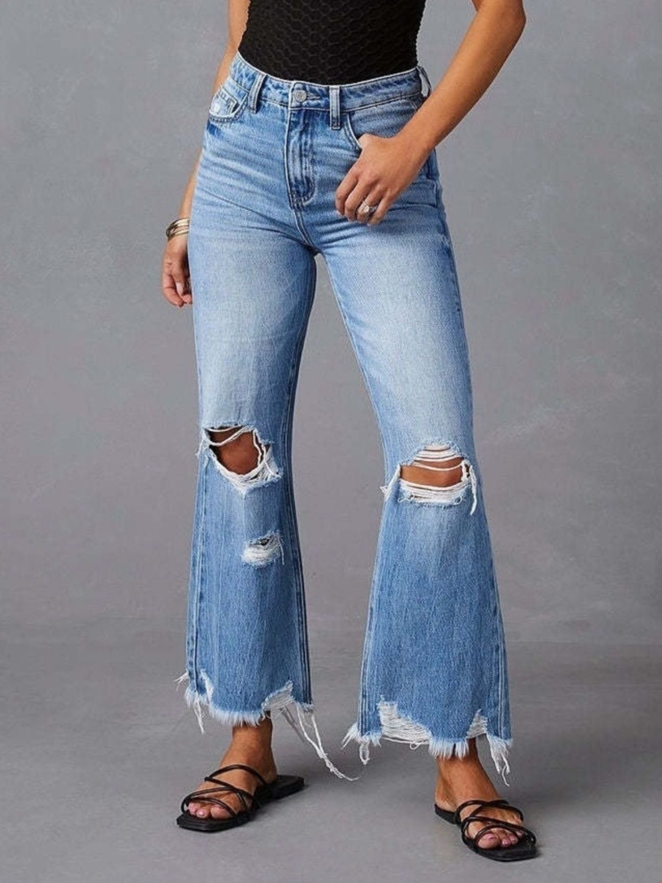 Blue distressed raw hem flare jeans from Trendsi, featuring a high-waisted fit and vintage-inspired design.