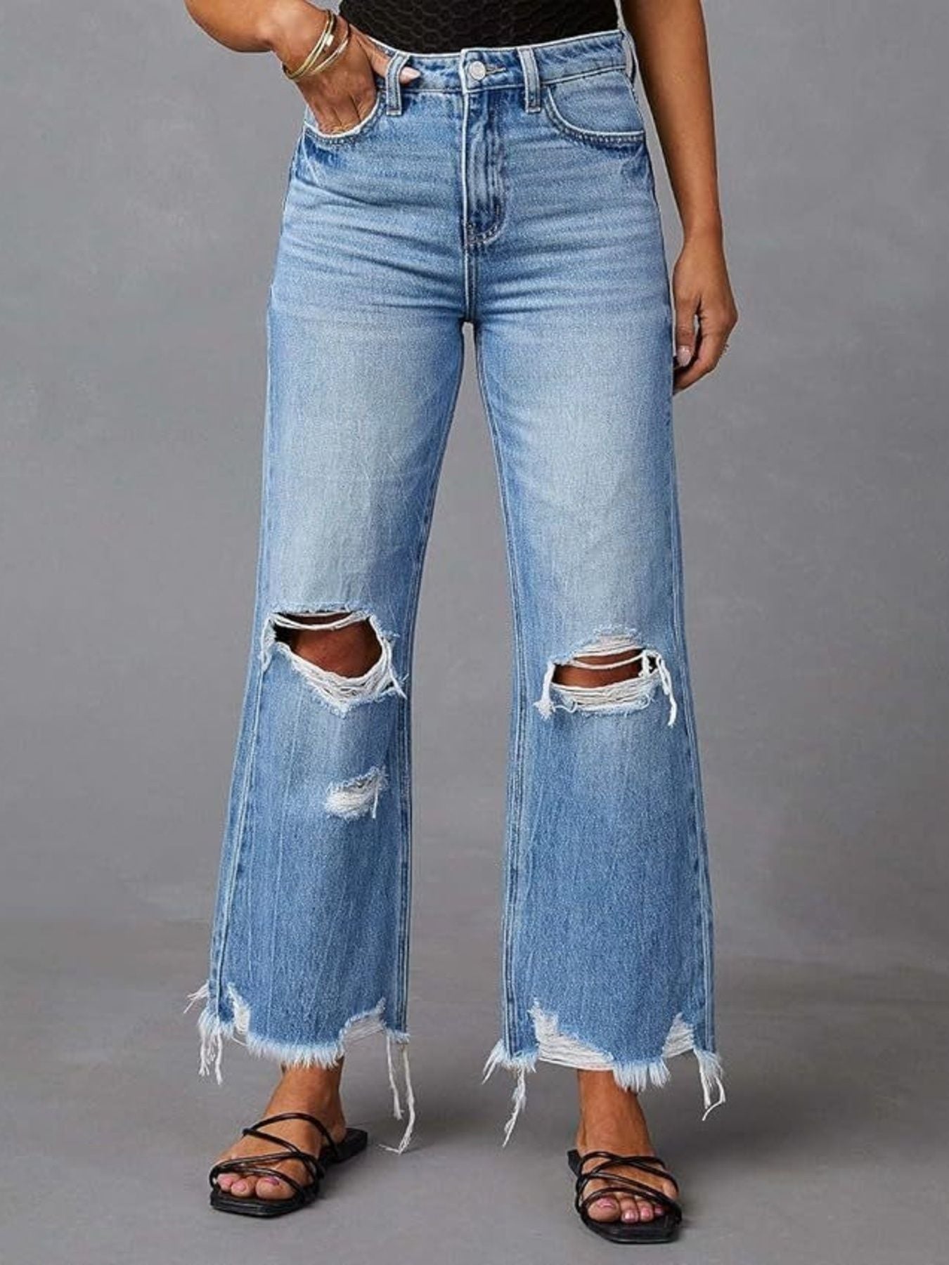 Blue distressed raw hem flare jeans by Trendsi, featuring a high-waisted fit and vintage-inspired distressed detailing.