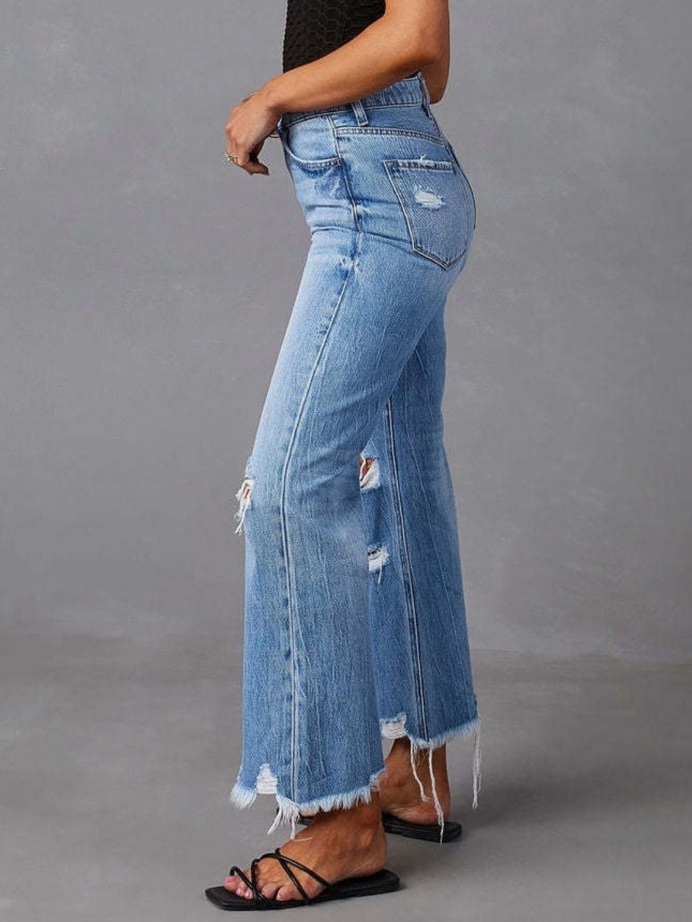 Blue distressed raw hem flare jeans from Trendsi, featuring a high-waisted fit and vintage-inspired design.
