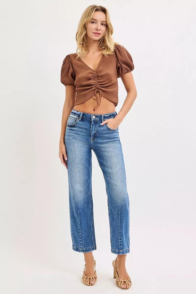 Dark wash RISEN high-rise crop boyfriend tapered jeans with distressed details and relaxed fit, styled on a model.