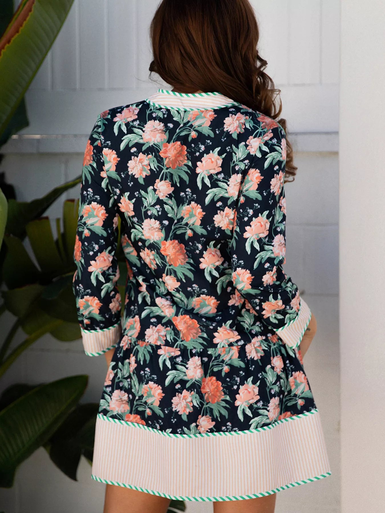 Floral print striped trim V-neck long sleeve shift mini dress with ruffle hem, by Trendsi, showcasing its vibrant pattern and feminine style.