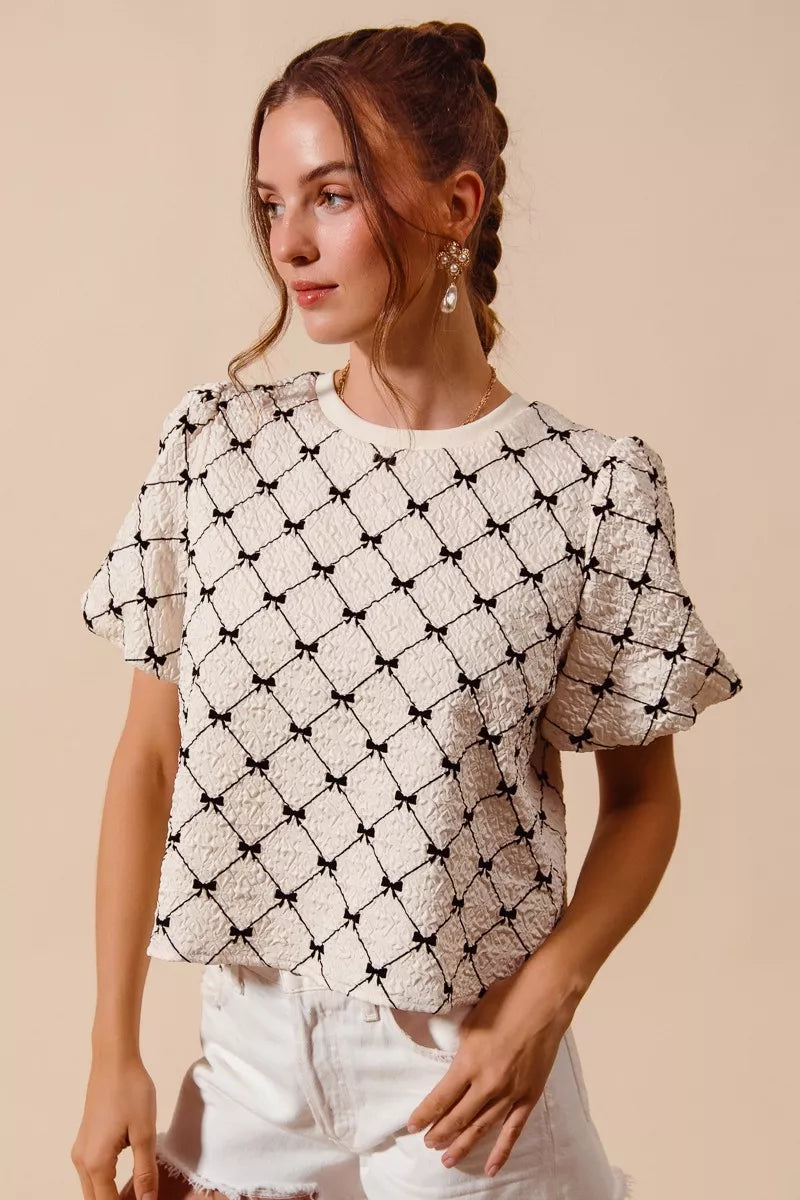 Ivory woven bubble sleeve top with bow texture from SO ME by Trendsi, featuring a stylish, textured fabric and puffed sleeves.