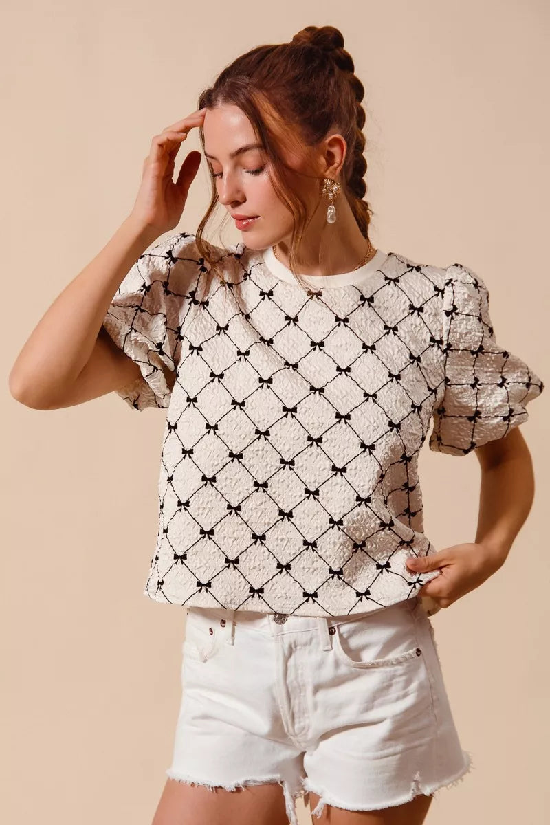 Ivory SO ME Bow Texture Woven Bubble Sleeve Top by Trendsi, featuring a stylish bow detail and textured fabric.