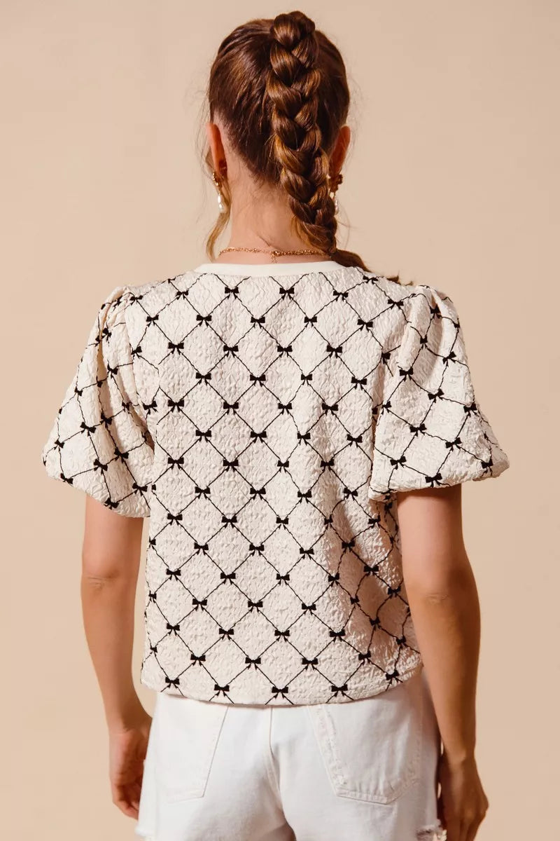 Ivory SO ME Bow Texture Woven Bubble Sleeve Top by Trendsi, showcasing its bow detail and textured fabric on a stylish blouse.