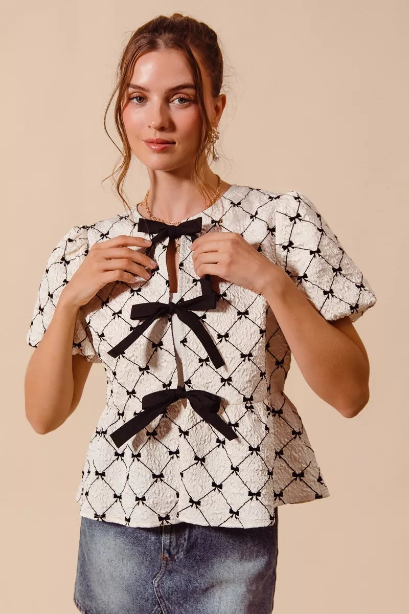 Ivory woven peplum top with bow texture and contrast tie by Trendsi, featuring a stylish and elegant design.