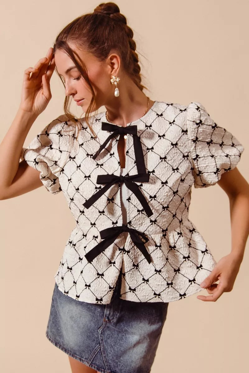 Ivory SO ME woven peplum top with bow texture and contrast tie, featuring a stylish and feminine design for casual or dressy outfits.