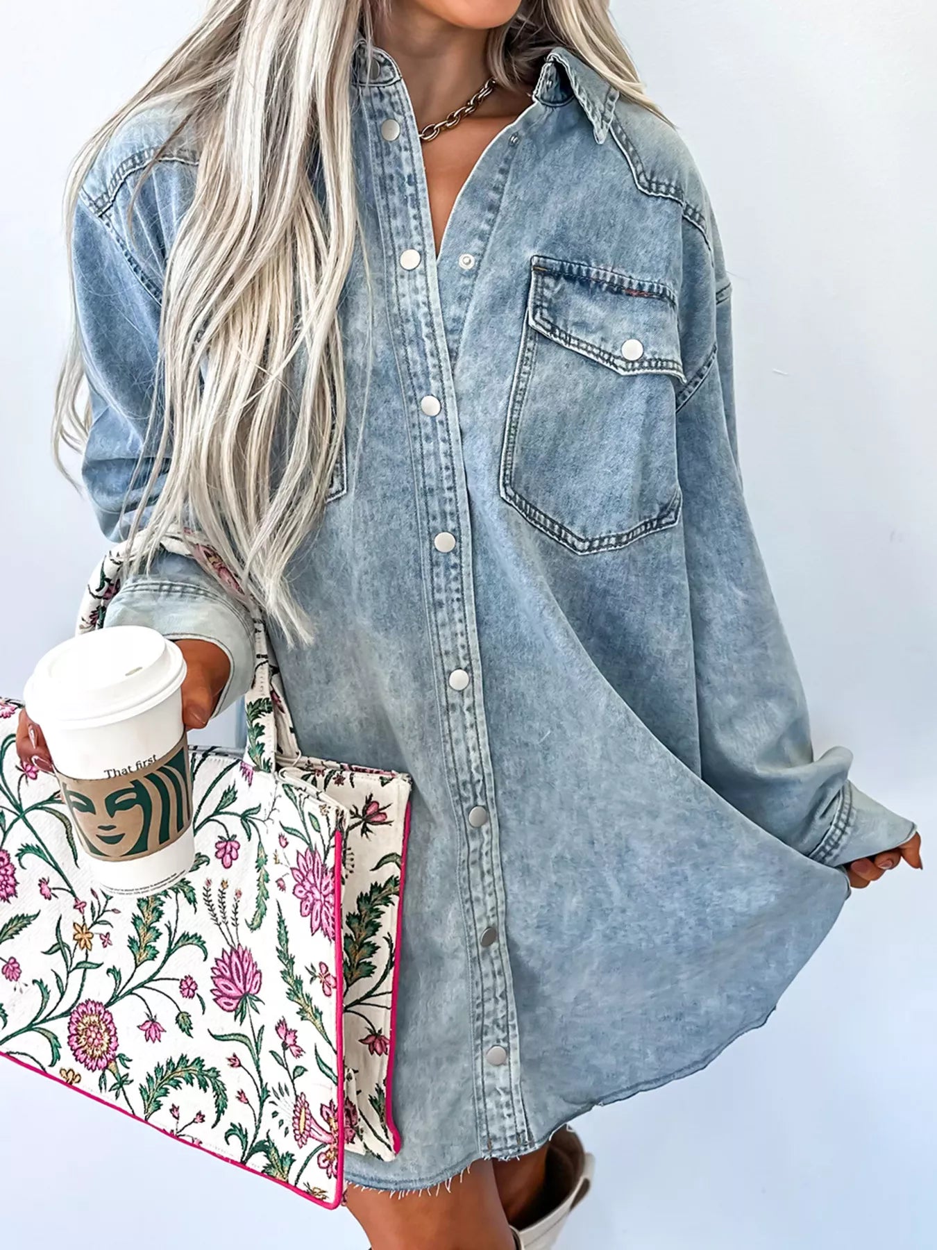 Light blue denim loose shirt dress with chest pocket and raw hem, featuring a relaxed fit and casual style.