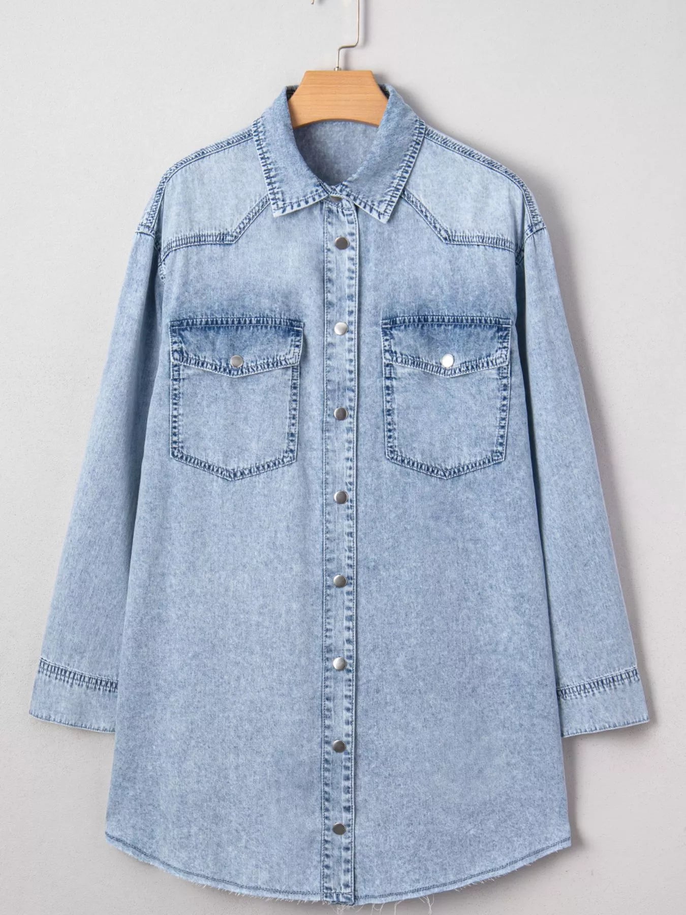 Light blue denim loose shirt dress with chest pocket and raw hem, featuring a relaxed fit and casual style.