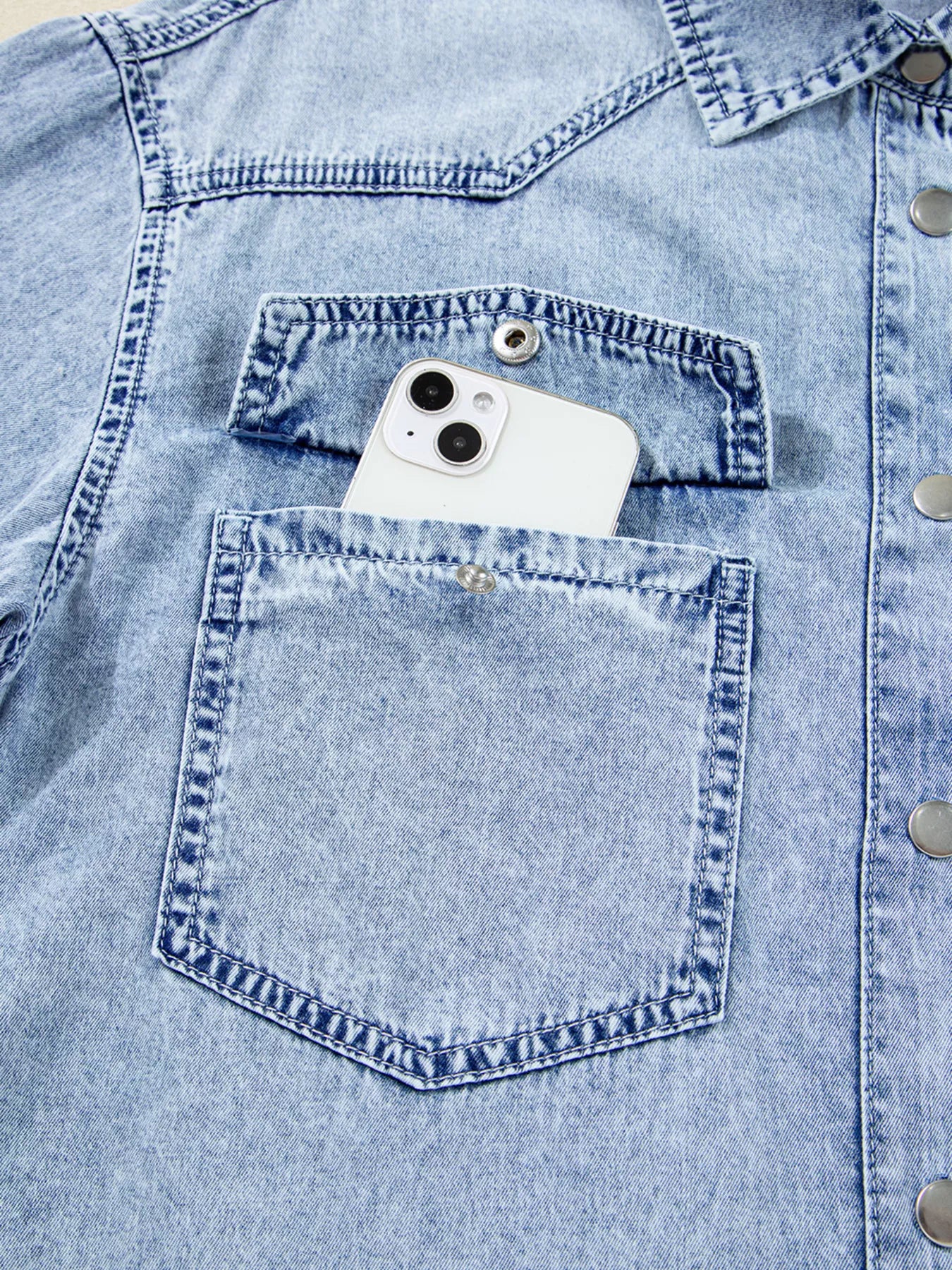Light blue denim shirt dress with chest pockets and raw hem, featuring a loose fit and casual style by Trendsi.
