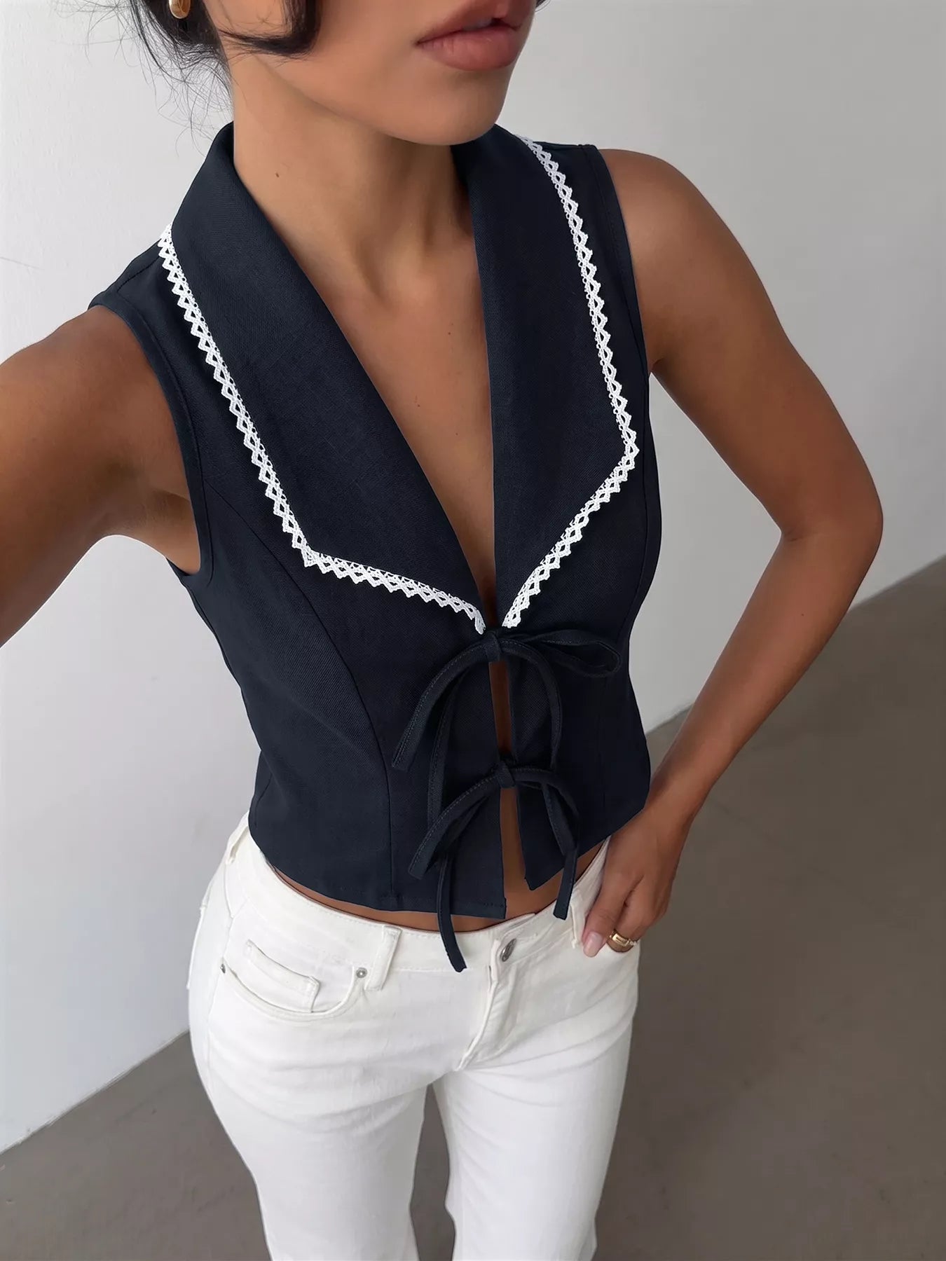 Navy blue lace trim tie-front vest by Trendsi, featuring a sleeveless design and delicate lace details.