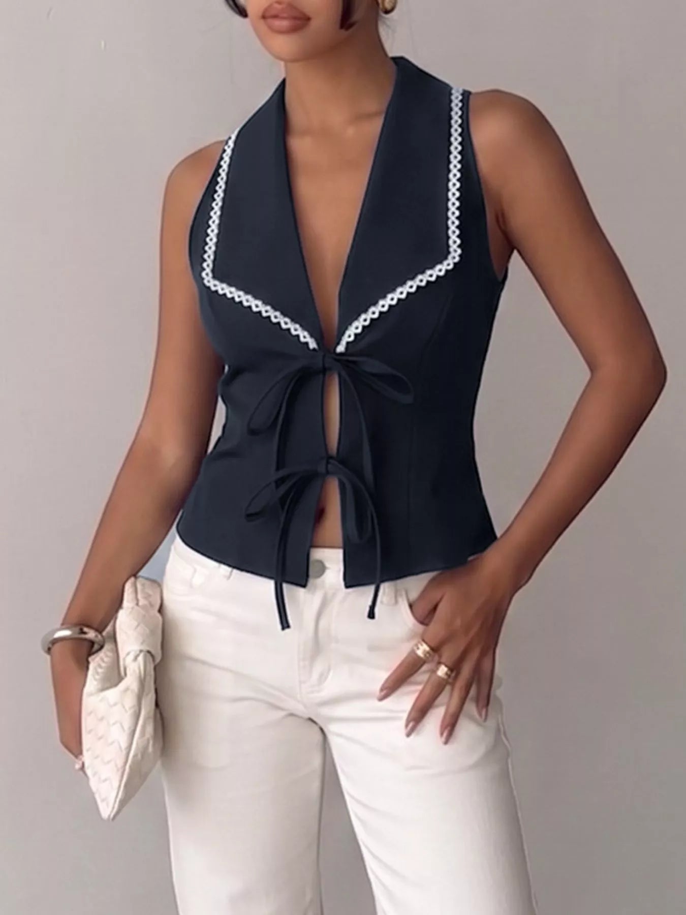 Navy blue lace-trim tie-front vest from Trendsi, featuring a sleeveless design and decorative lace detailing.